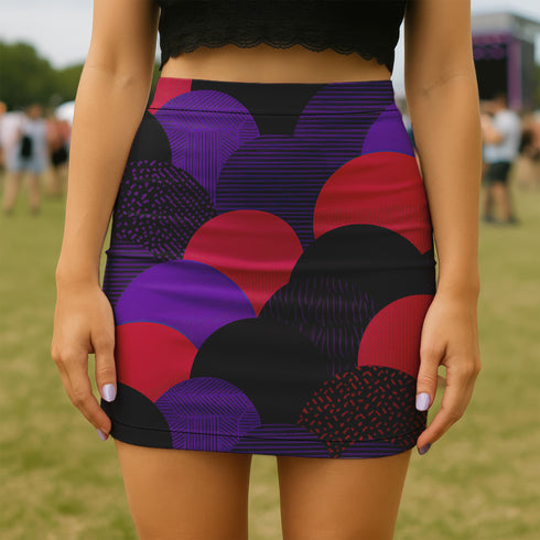 A woman wearing a short skirt with a colorful, abstract pattern of circles and lines in shades of purple, red, and black.
